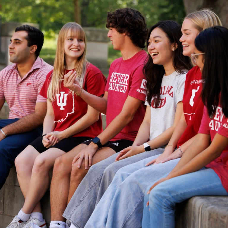 A group of students in IU apparel discuss ideas outside on campus